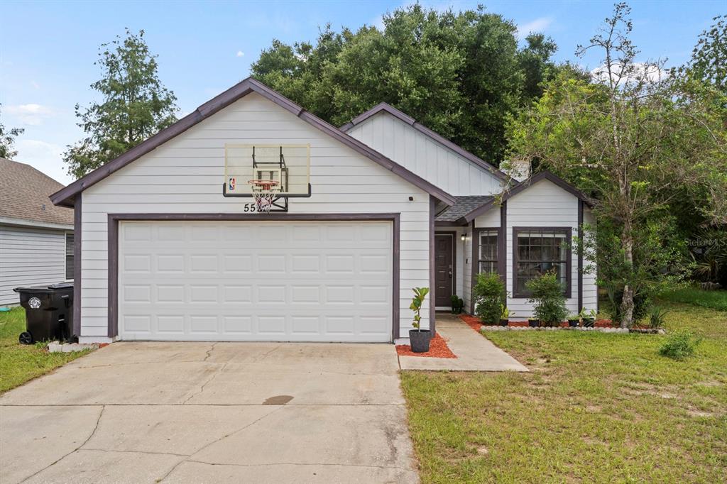 A single-story house with white horizontal siding, a two-car garage, and a basketball hoop — 555 SWALLOW COURT, APOPKA, FL