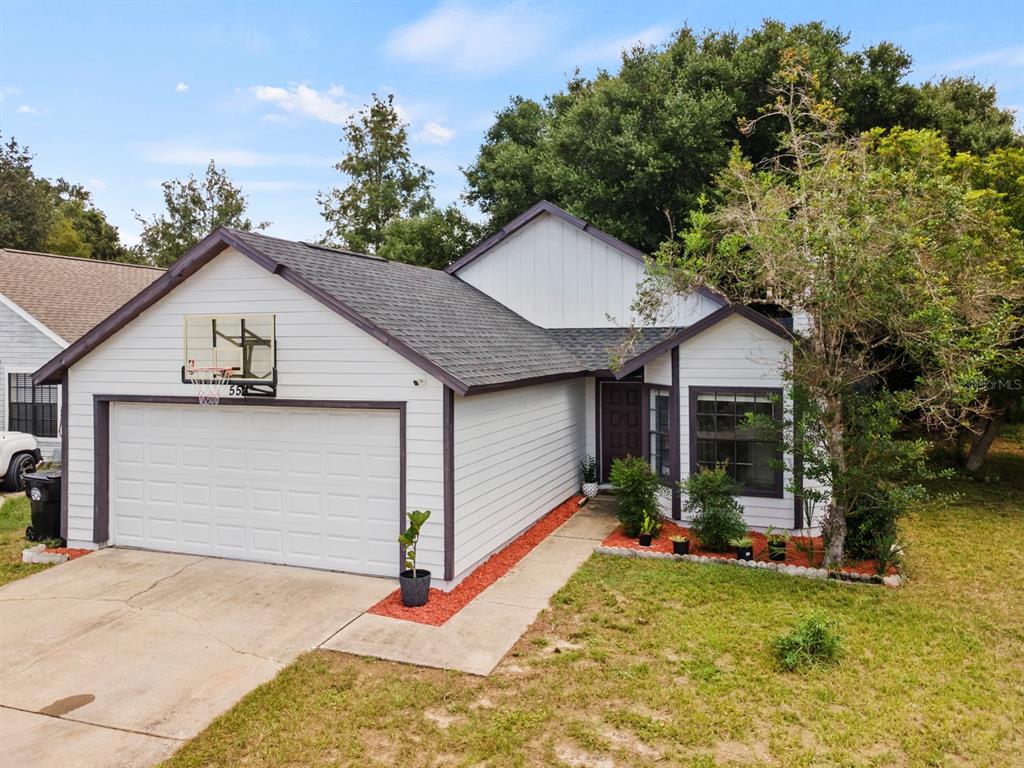 A single-story house with white siding, a two-car garage, and a basketball hoop — 555 SWALLOW COURT, APOPKA, FL