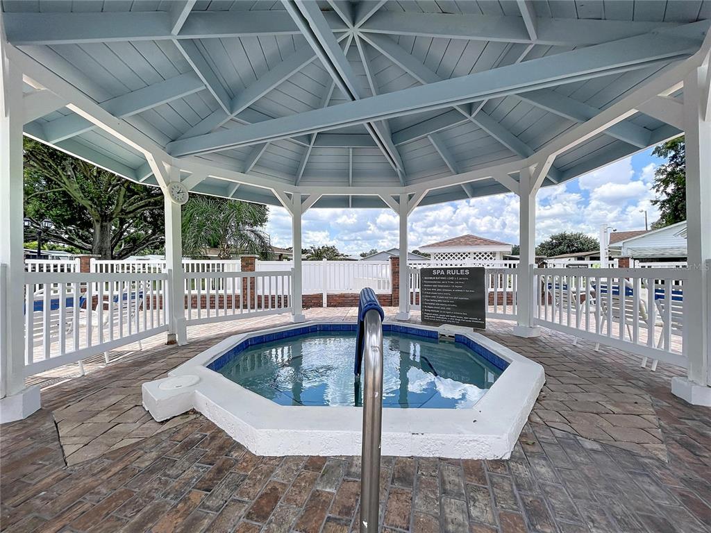 An outdoor octagonal hot tub sits under a gazebo with a white railing and roof — 4983 PLEASANT HOLLOW TRAIL, LAKELAND, FL