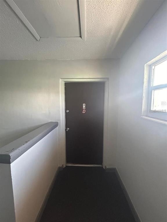A dark door labeled D is at the end of a hallway with white walls — 1627 W OAK RIDGE ROAD UNIT D, ORLANDO, FL
