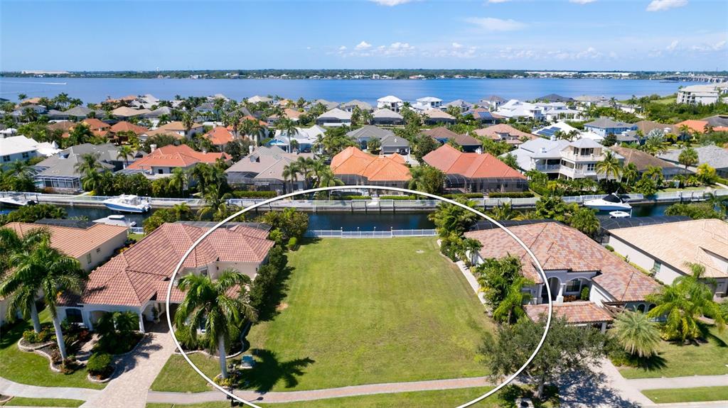 An aerial view shows a vacant residential lot situated between two houses along a canal — 540 MAST DRIVE, BRADENTON, FL