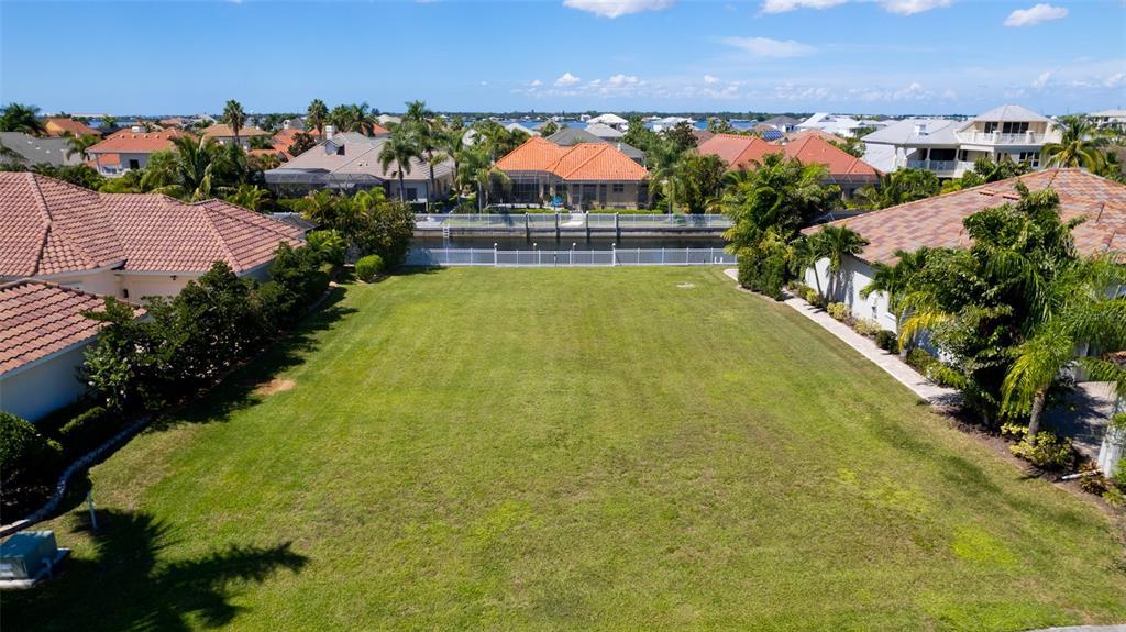 An aerial view shows a vacant residential lot situated between two houses near a canal — 540 MAST DRIVE, BRADENTON, FL