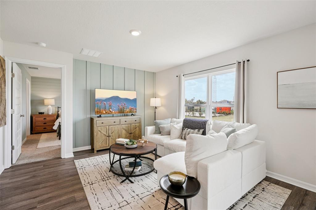 A living room features a light blue accent wall, white sofa, and wood-look flooring — 4410 BLACKWELL AVENUE, LAKE WALES, FL