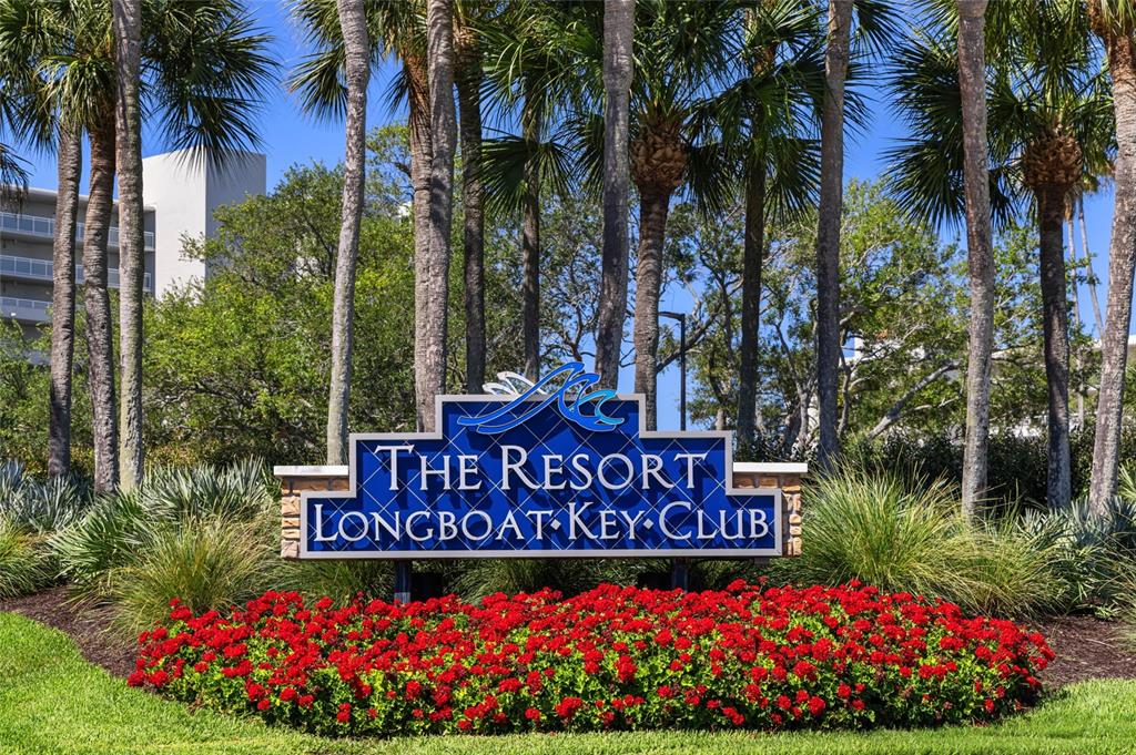 A blue sign for The Resort at Longboat Key Club sits behind red flowers — 210 SANDS POINT ROAD UNIT 2101, LONGBOAT KEY, FL