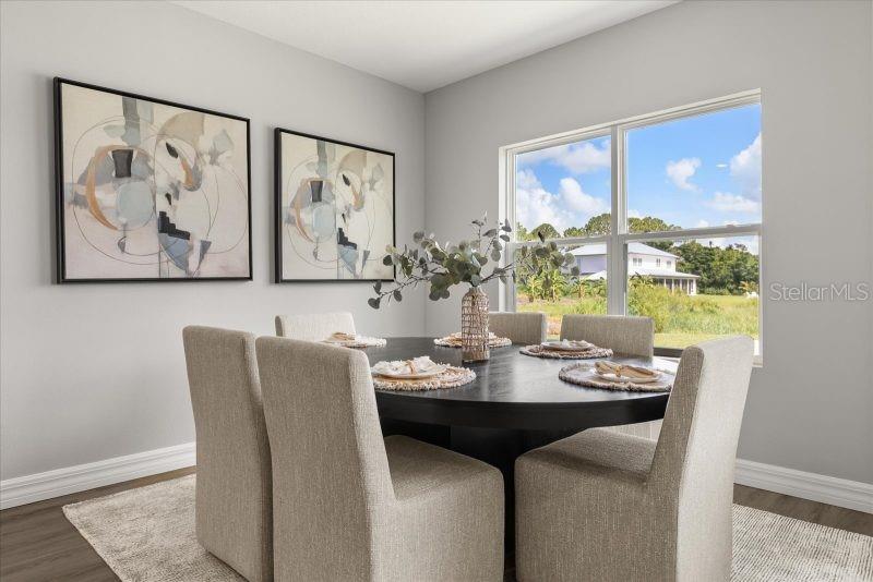 A dining room features a round black table, upholstered chairs, and two abstract wall paintings — 10121 SW 45TH AVENUE, OCALA, FL