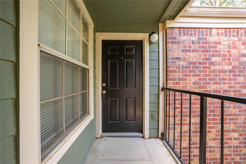 A black front door with the number 334 is situated on a covered outdoor balcony — 2210 YANKEE PLACE UNIT 334, ORLANDO, FL