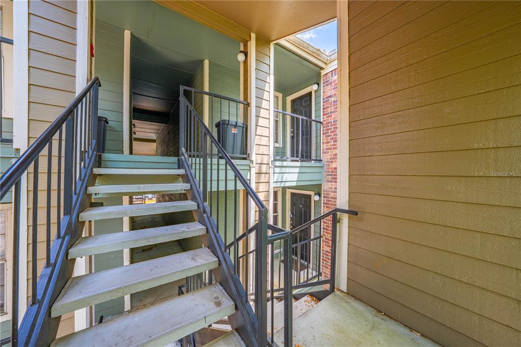 An exterior view of an apartment building staircase leading to two levels of entry doors — 2210 YANKEE PLACE UNIT 334, ORLANDO, FL