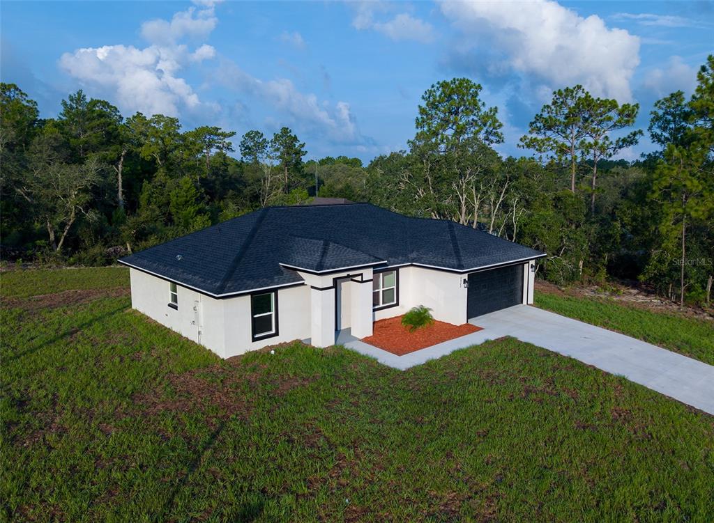 An aerial view of a single-story house with a white exterior and a dark roof — 2902 W EDISON PLACE, DUNNELLON, FL