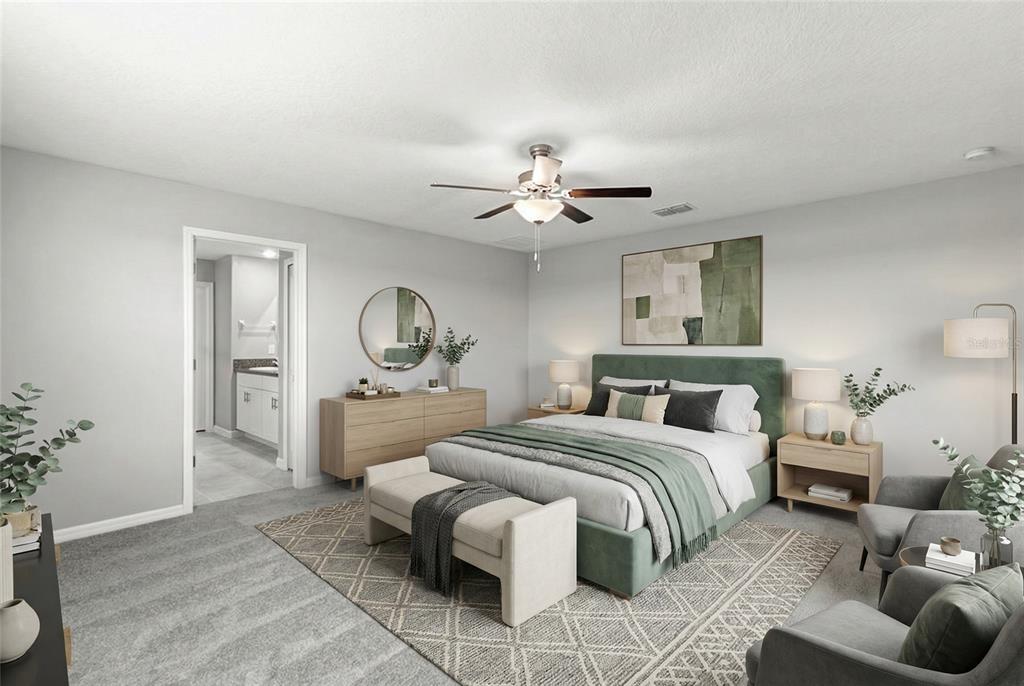 This bedroom features a green upholstered bed, light wood furniture, and a neutral area rug — 5351 NIGHT TIDE LANE, WIMAUMA, FL