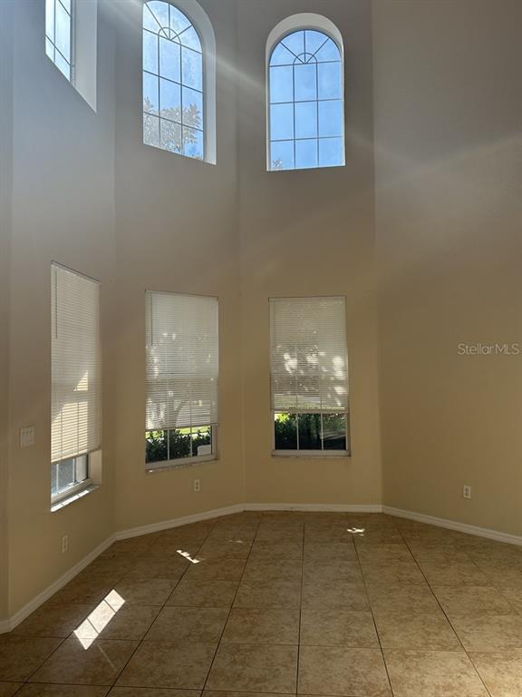 A sunlit room with tile flooring, high ceilings, and multiple arched and rectangular windows — 18048 JAVA ISLE DRIVE, TAMPA, FL