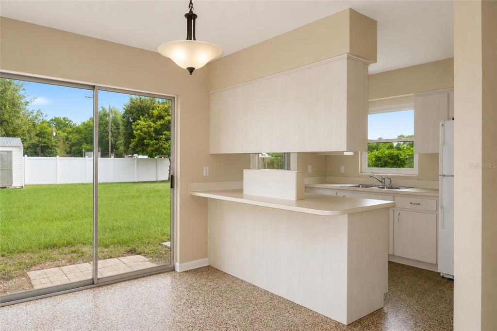 A kitchen with light wood cabinets, a breakfast bar, and a sliding glass door — 6008 BOB HEAD ROAD, PLANT CITY, FL
