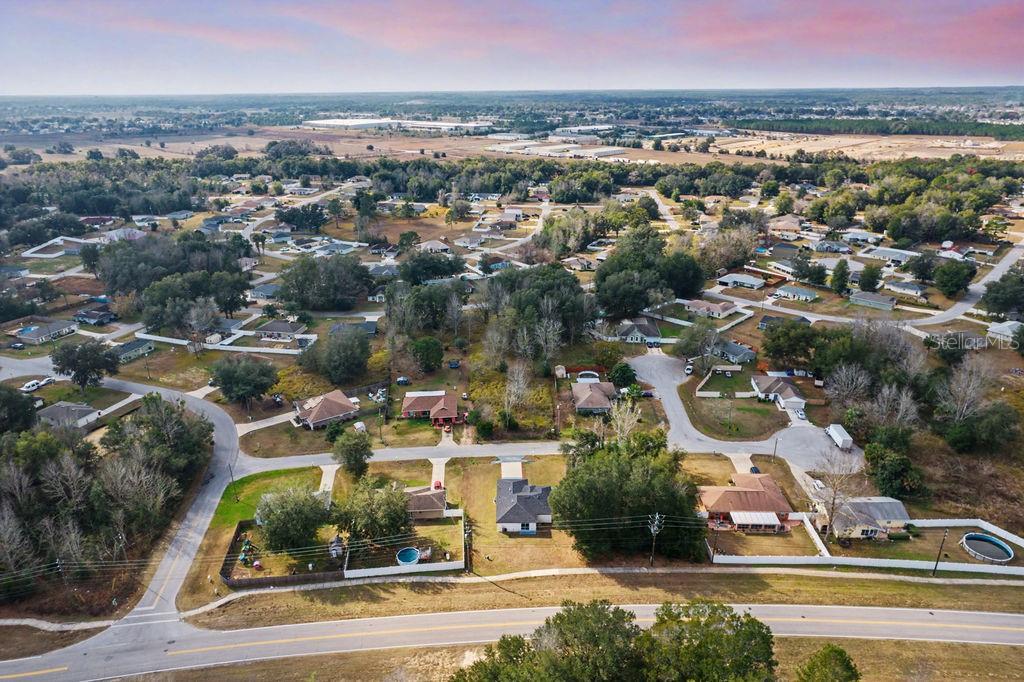 An aerial view shows a suburban neighborhood with houses, trees, and a paved road — 5 PINE TRACK PLACE, OCALA, FL