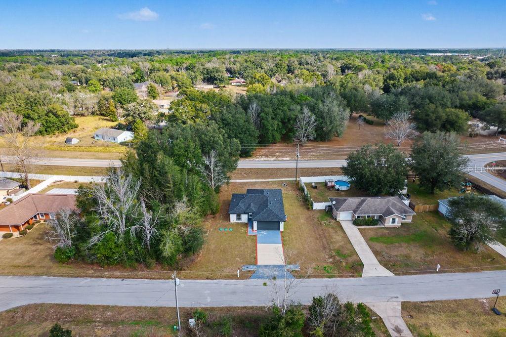 An aerial view shows a single-story house with a dark roof and a concrete driveway — 5 PINE TRACK PLACE, OCALA, FL