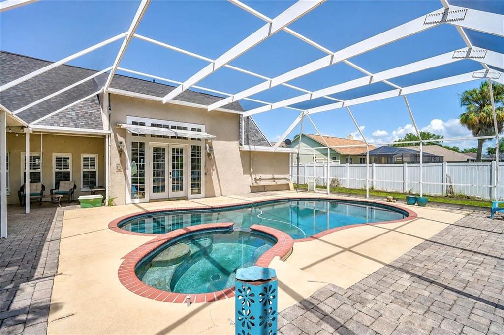 A backyard swimming pool and attached spa are enclosed by a white screen cage — 8814 RIVERLACHEN WAY, RIVERVIEW, FL