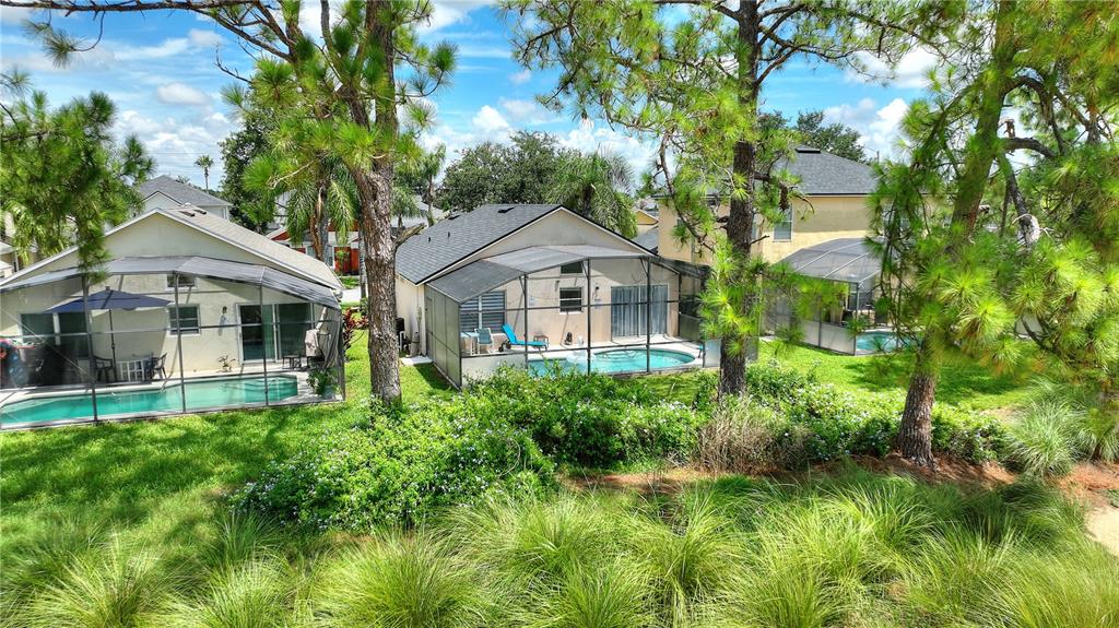 An elevated view of three houses with screened-in pools and backyards surrounded by pine trees — 2960 KOKOMO LOOP LOOP, HAINES CITY, FL