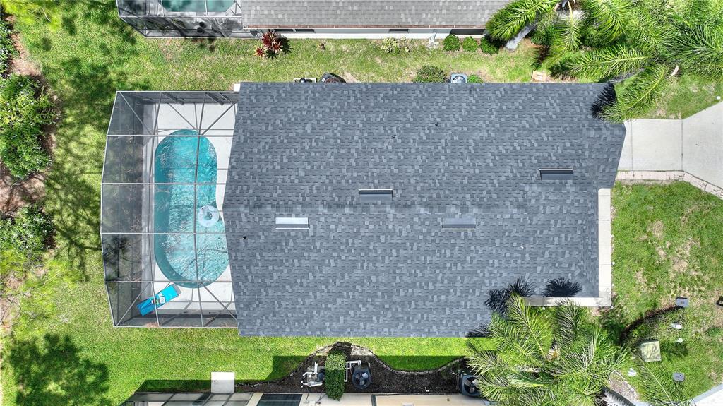 An aerial view shows a house with a dark shingled roof and a screened-in pool — 2960 KOKOMO LOOP LOOP, HAINES CITY, FL