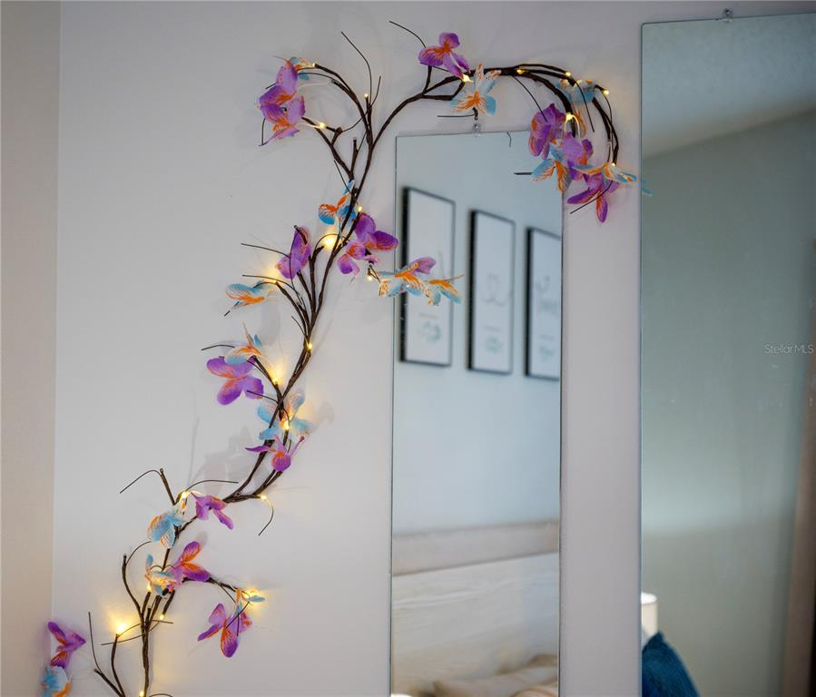 A wall-mounted mirror is decorated with an illuminated artificial floral vine — 2960 KOKOMO LOOP LOOP, HAINES CITY, FL