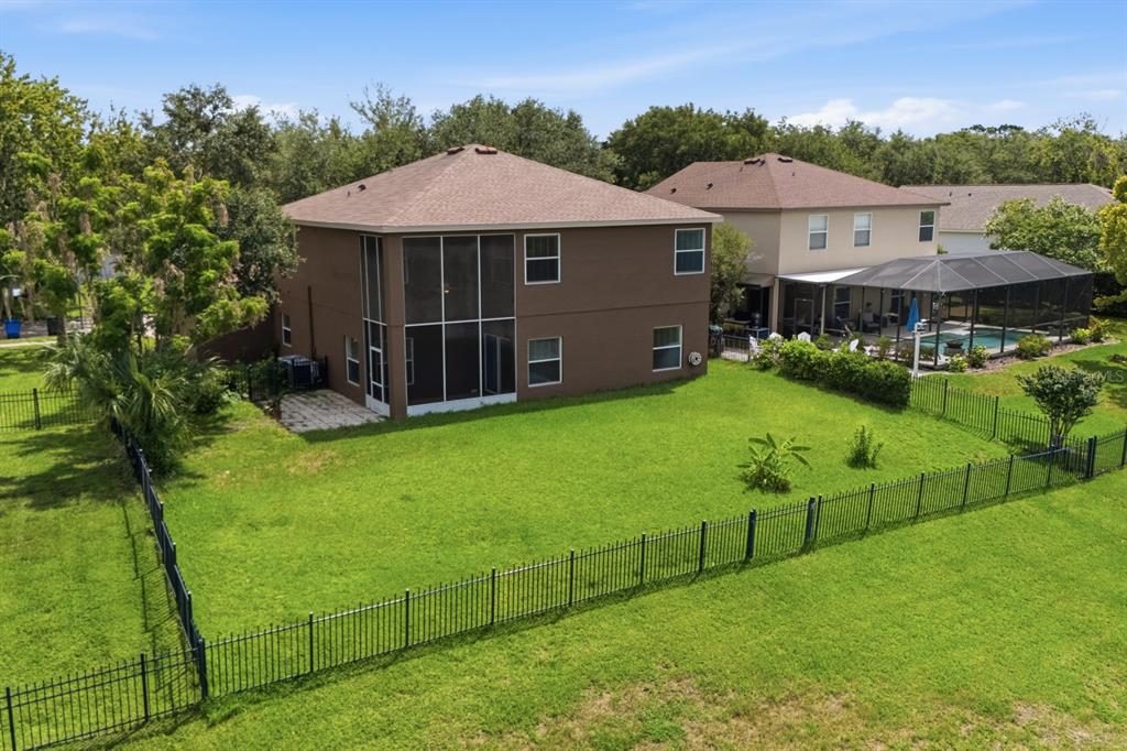 An aerial view of the brown two-story house exterior with a fenced backyard — 14722 HERONGLEN DRIVE, LITHIA, FL