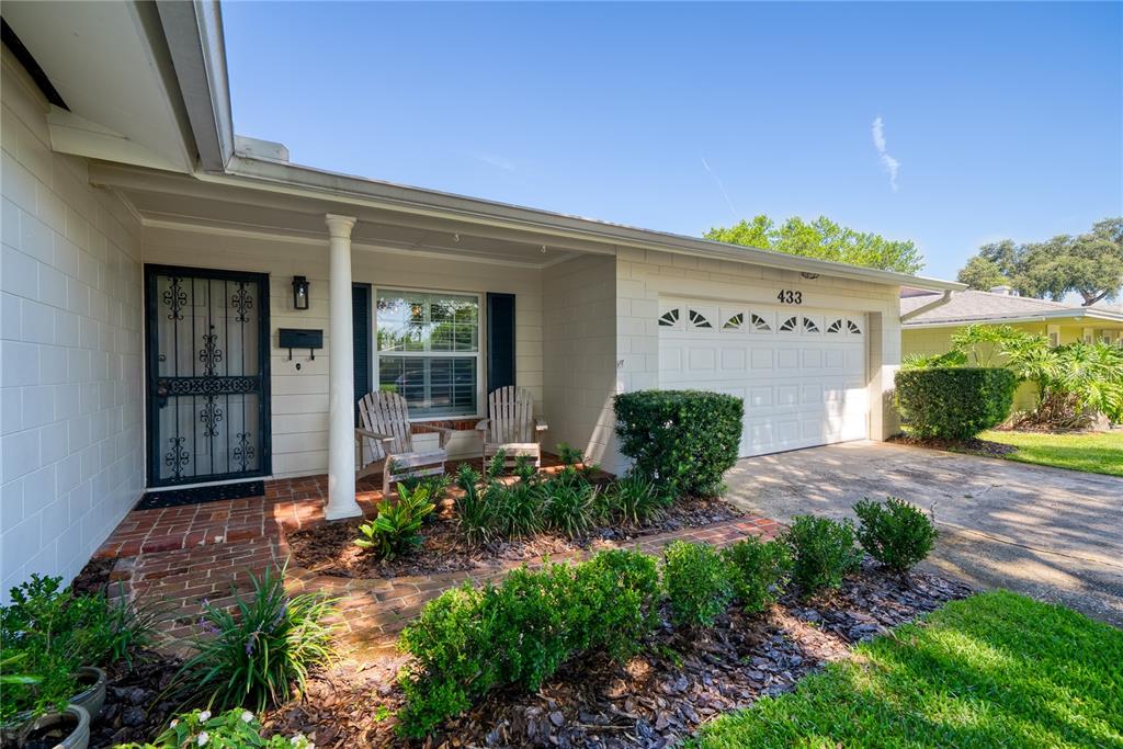 A single-story house with a white brick exterior, a garage, and a front porch — 433 GILBERT ROAD, WINTER PARK, FL