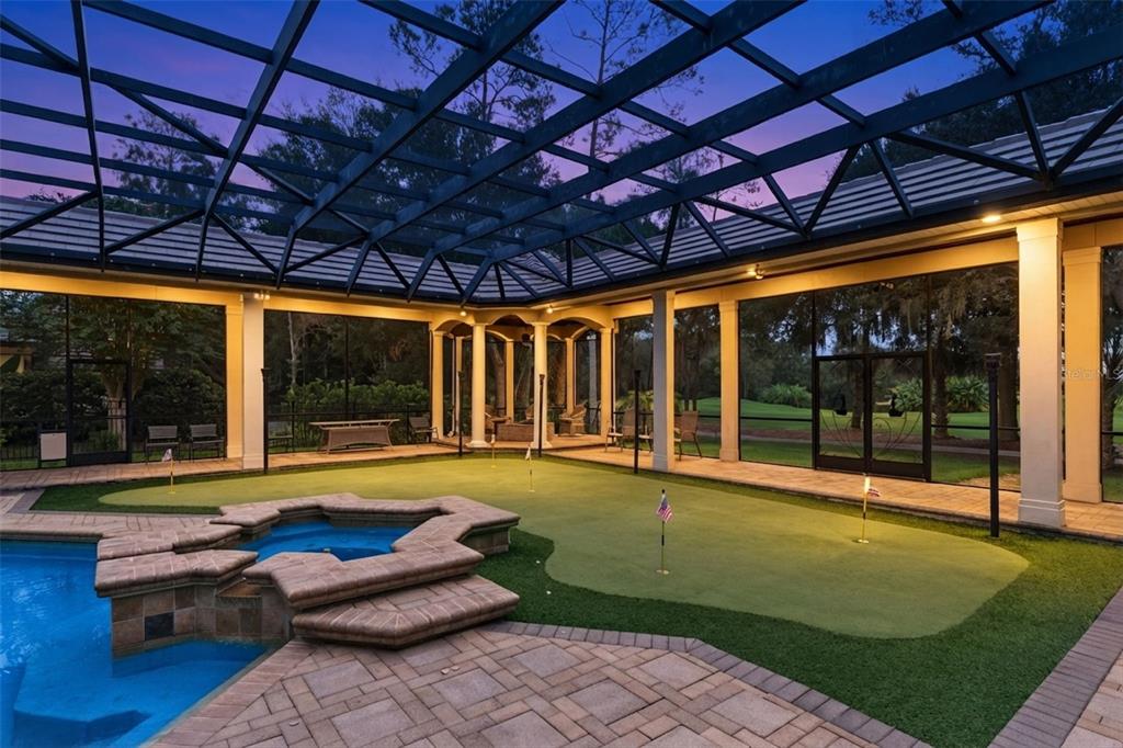 A screened-in patio features a swimming pool, a hot tub, and a backyard putting green — 3355 LAKEVIEW OAKS DRIVE, LONGWOOD, FL