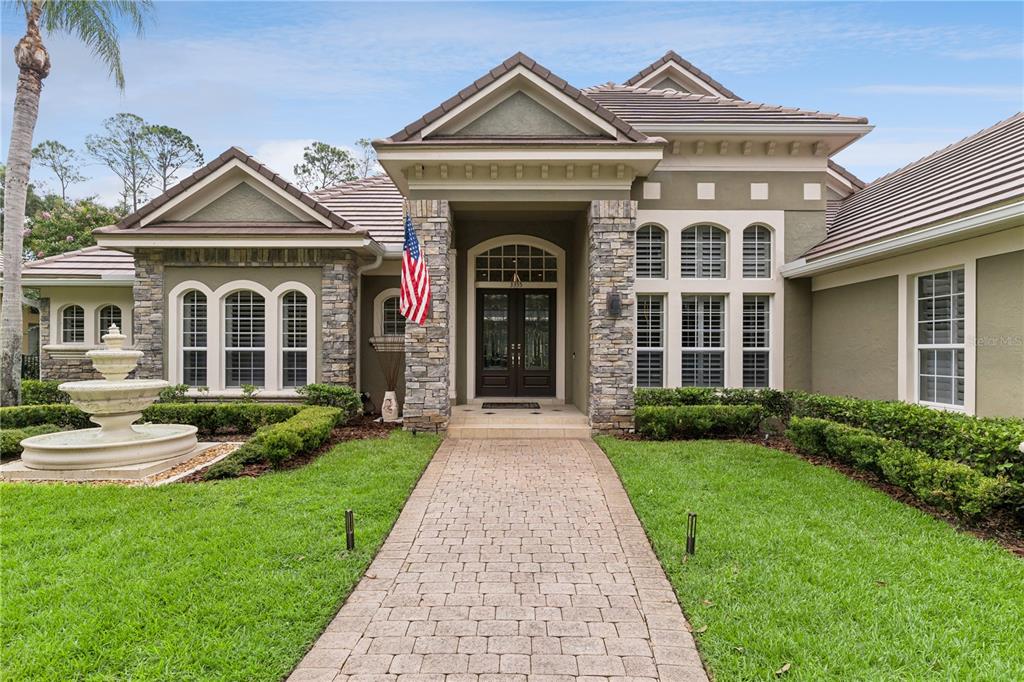 A single-story house with a stone-accented entrance, a paved walkway, and a front yard fountain — 3355 LAKEVIEW OAKS DRIVE, LONGWOOD, FL