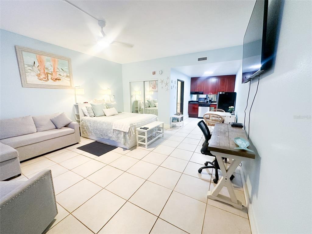 A studio apartment features a bed, sofa, desk, and kitchen with tile flooring throughout — 611 DESTINY DRIVE UNIT 501, RUSKIN, FL