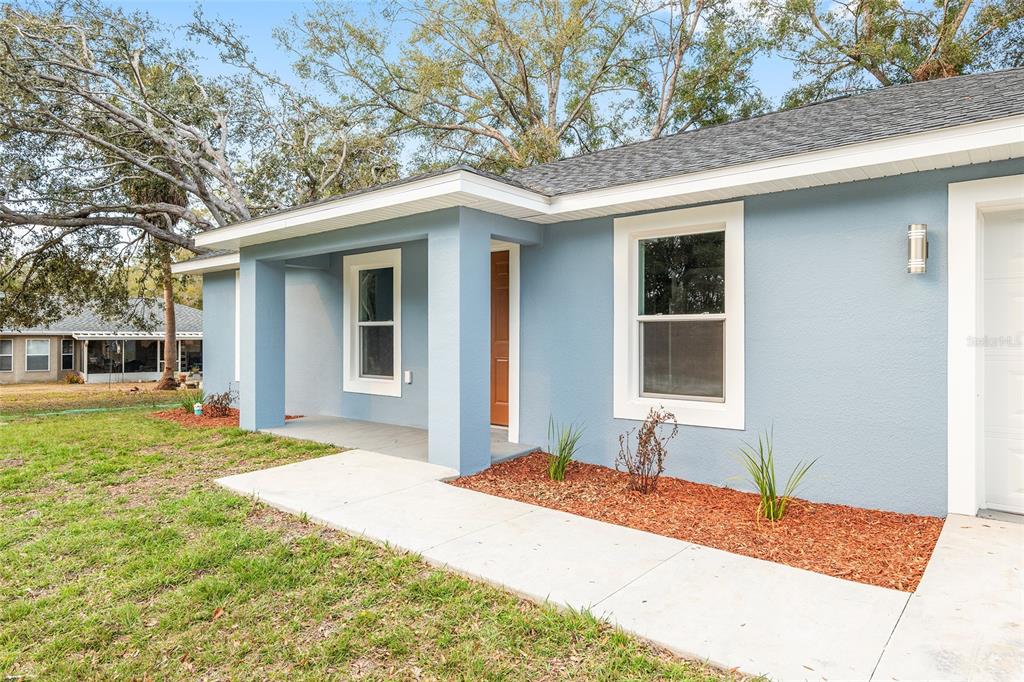 A single-story house with blue siding, a brown front door, and an attached garage — 2688 SW 150TH COURT, OCALA, FL