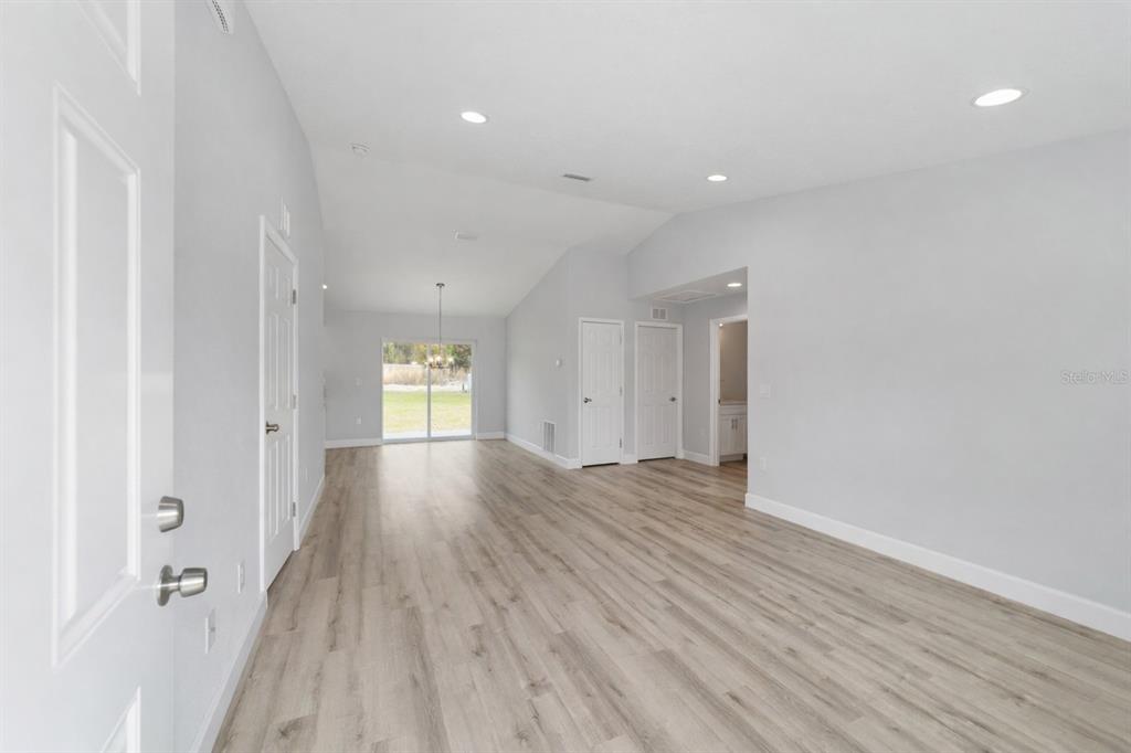 The exterior of a light blue house features a covered porch, brown door, and windows — 2688 SW 150TH COURT, OCALA, FL