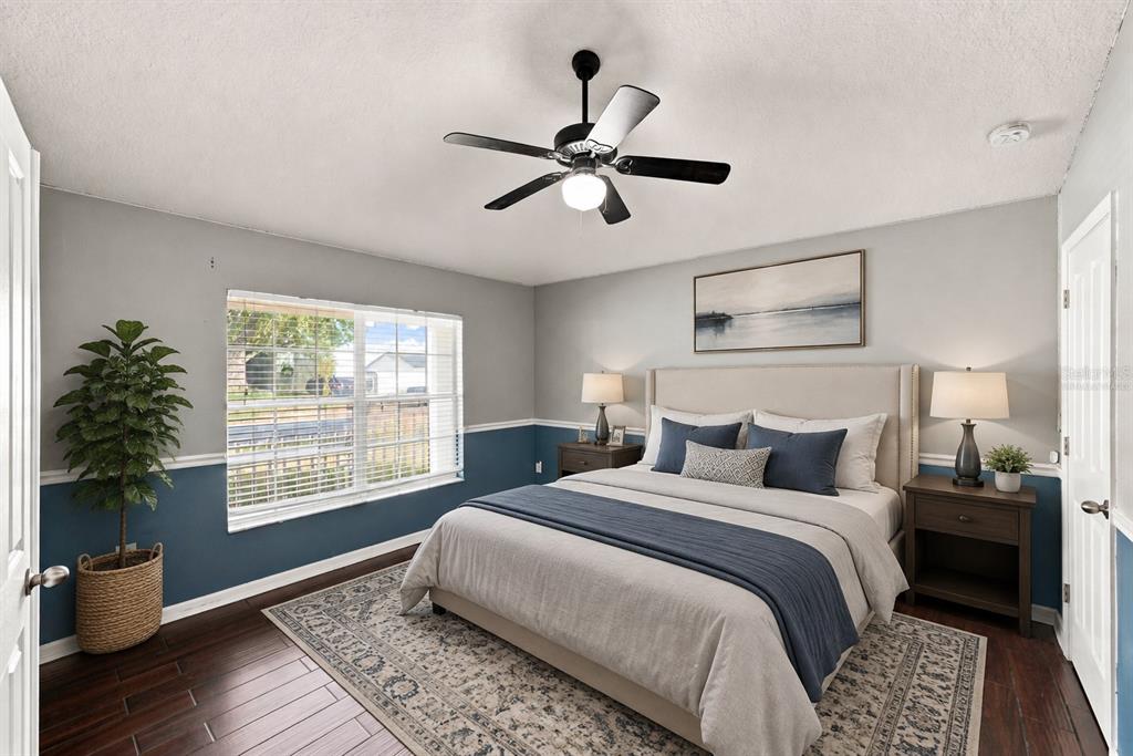 A bedroom features a bed with blue accents, two-toned walls, and a ceiling fan — 13368 MANDALAY PLACE, SPRING HILL, FL