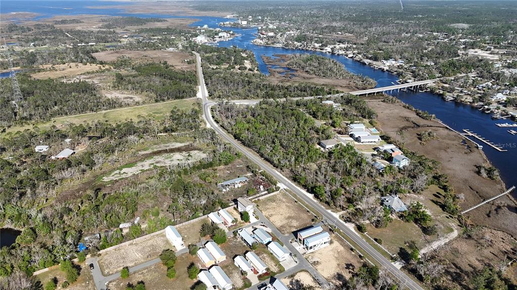 An aerial view shows a coastal area with a road, scattered houses, and a waterway — 000 SW 879TH STREET, STEINHATCHEE, FL