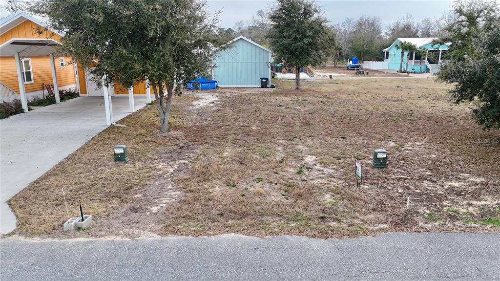 A vacant residential lot sits between a yellow house and a light blue shed — 000 SW 879TH STREET, STEINHATCHEE, FL