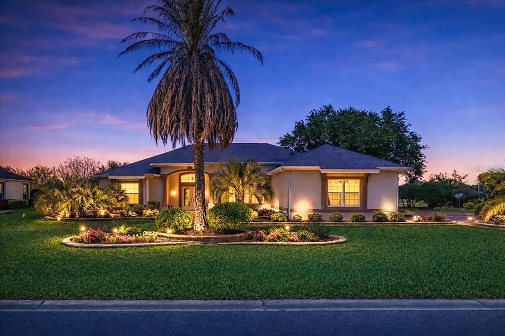 A single-story house with a palm tree in the front yard at twilight — 1670 SAINT JAMES CIRCLE, THE VILLAGES, FL