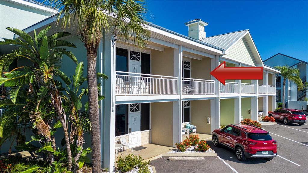 The exterior of a two-story building features white railings, balconies, and a red SUV parked nearby — 611 DESTINY DRIVE UNIT 403, RUSKIN, FL