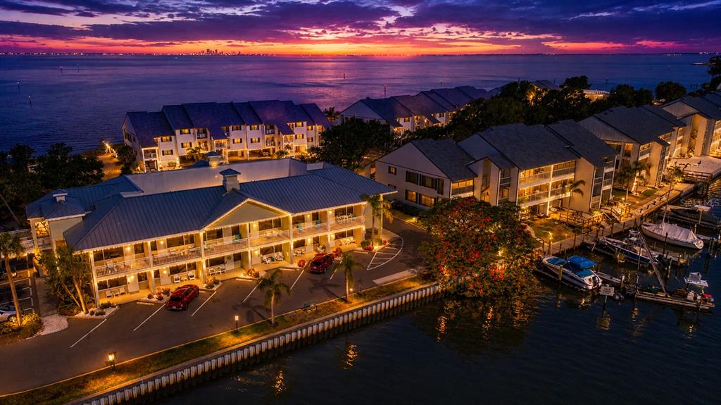 An aerial view of waterfront apartment buildings at sunset with a boat dock and parking — 611 DESTINY DRIVE UNIT 403, RUSKIN, FL