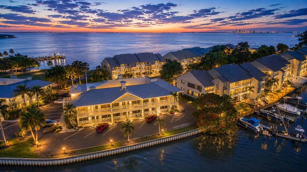 An aerial view of waterfront condominiums at sunset with a parking lot and boat slips — 611 DESTINY DRIVE UNIT 403, RUSKIN, FL