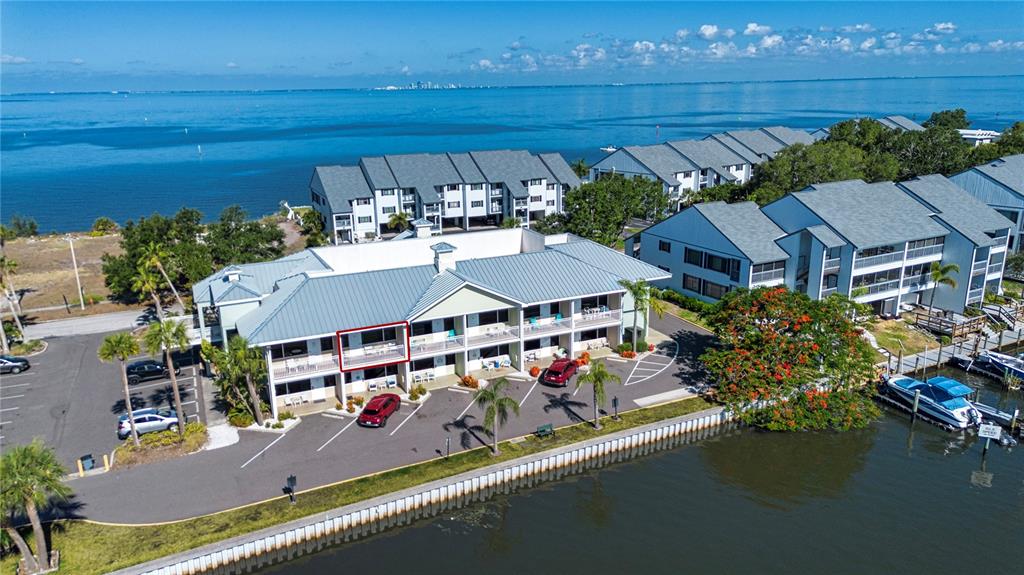 An aerial view shows a waterfront condominium complex with a red-outlined balcony on the second floor — 611 DESTINY DRIVE UNIT 403, RUSKIN, FL
