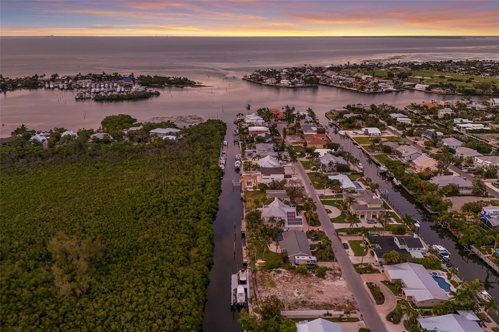 An elevated view of a vacant waterfront lot with two boats docked in the canal — 508 77TH STREET, BRADENTON BEACH, FL