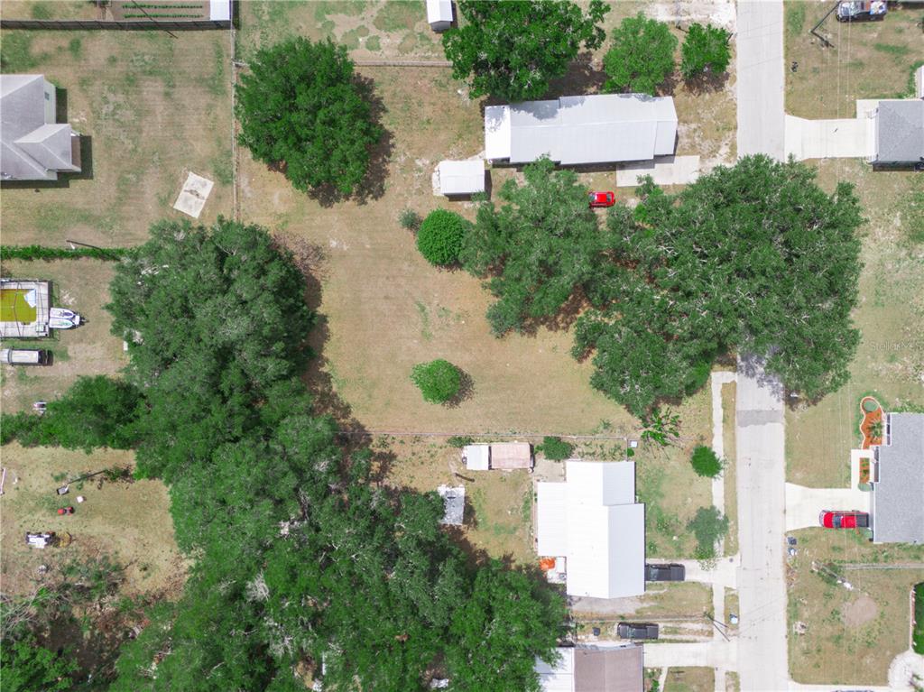 An aerial view shows a vacant residential lot surrounded by trees and neighboring houses — 0 S PERRY AVENUE, FORT MEADE, FL