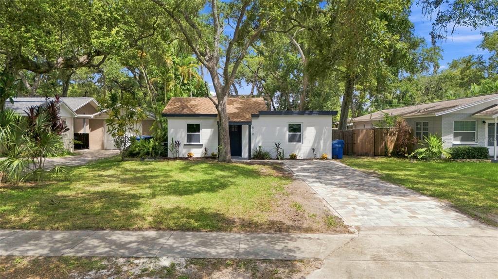 A single-story white house with a brown shingled roof and a paved driveway — 510 3RD AVENUE NE, LARGO, FL