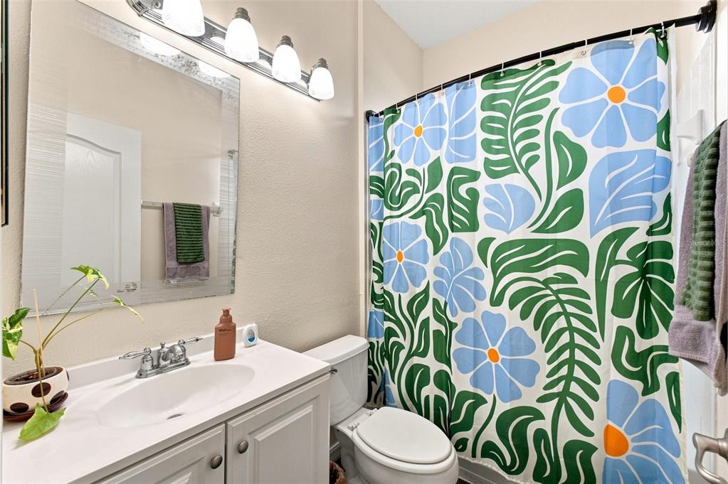 A bedroom features a bed, a white closet, a ceiling fan, and an open doorway — 4327 CANONGATE COURT, SPRING HILL, FL