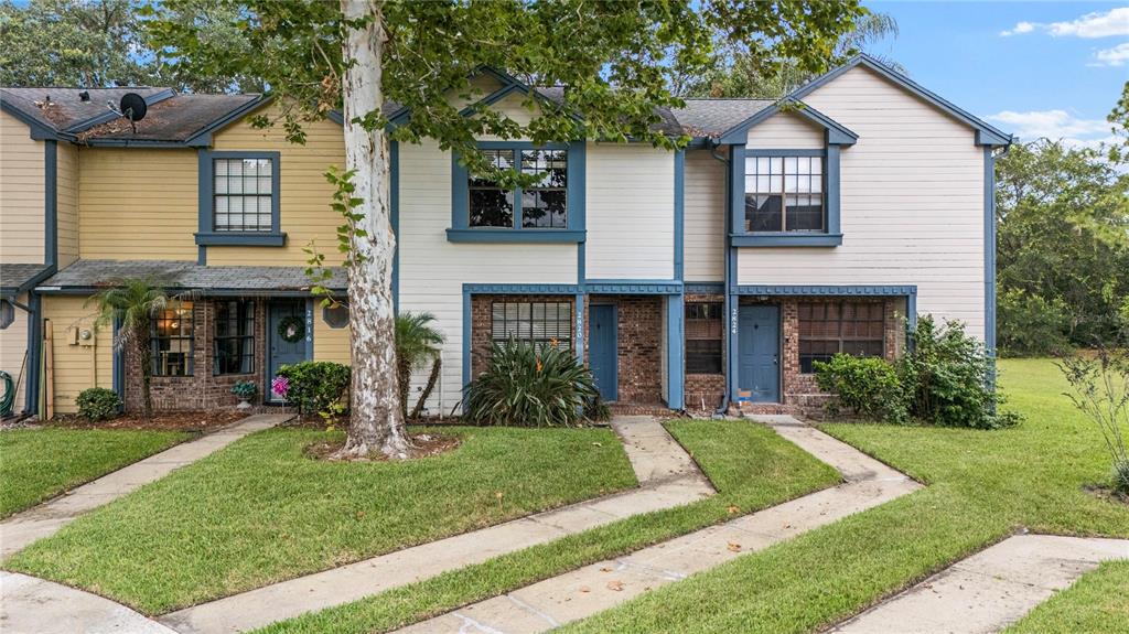 A row of three two-story townhouses with siding, brick accents, and individual front walkways — 2820 REVERE COURT, CASSELBERRY, FL