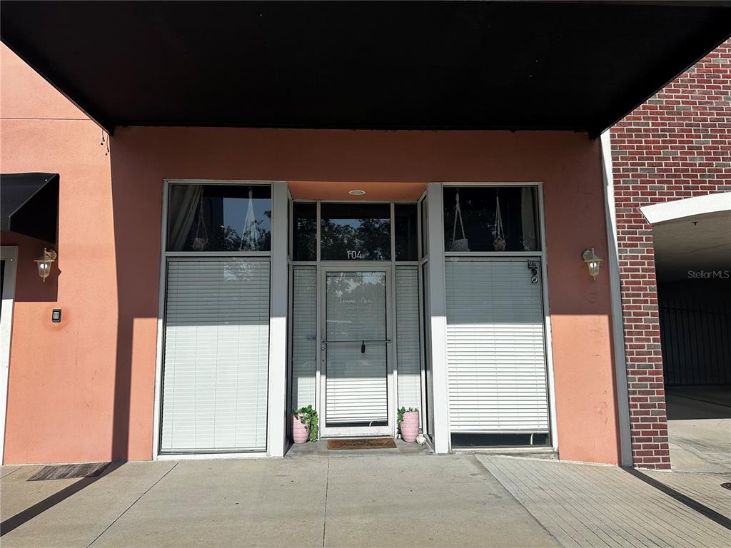 The exterior of a commercial storefront features a glass door, large windows, and pink walls — 2002 E 5TH AVENUE UNIT 104, TAMPA, FL