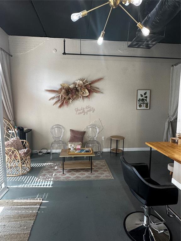 A salon waiting area features two clear chairs, a coffee table, and a decorative floral arrangement — 2002 E 5TH AVENUE UNIT 104, TAMPA, FL