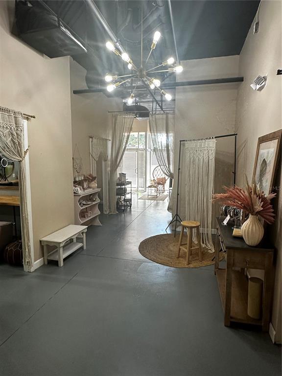 A commercial space features a modern sputnik chandelier, concrete floors, and bohemian-style decor — 2002 E 5TH AVENUE UNIT 104, TAMPA, FL