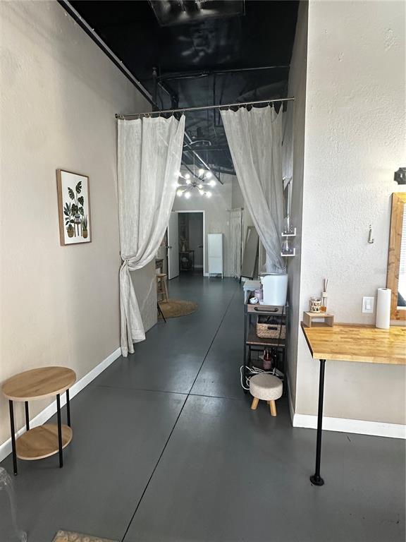 A room features a gray floor, a curtained doorway, a rolling cart, and a wooden desk — 2002 E 5TH AVENUE UNIT 104, TAMPA, FL