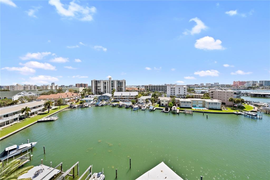 An elevated view of a coastal waterway lined with residential buildings, docks, and boats — 211 SKIFF POINT UNIT 2A, CLEARWATER, FL