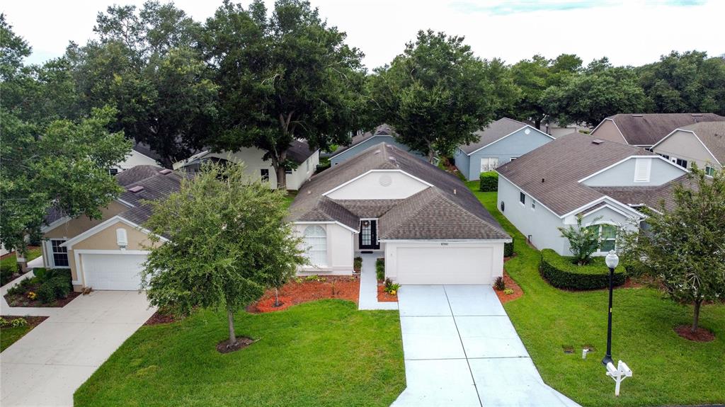 An aerial view of a single-story suburban house with a two-car garage and driveway — 3622 WESTERHAM DRIVE, CLERMONT, FL