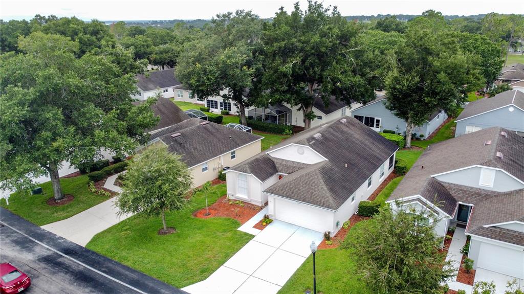 An aerial view of a suburban neighborhood featuring single-story houses with driveways and mature trees — 3622 WESTERHAM DRIVE, CLERMONT, FL