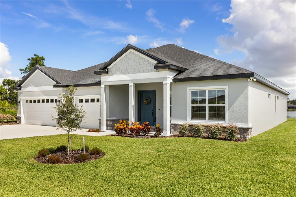 A single-story house with a light gray exterior, a two-car garage, and a covered entryway — 5315 SAVONA DRIVE, SEBRING, FL