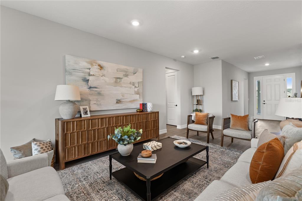 A living room features a wooden console table, a black coffee table, and two armchairs — 5315 SAVONA DRIVE, SEBRING, FL